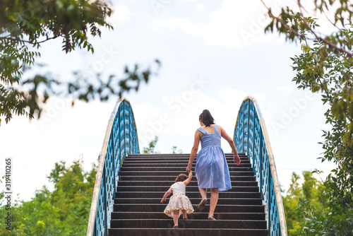 Fotografie Mother and daughter go up the stairs