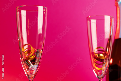 Champagne glasses with party tinsel on bright background © fotofabrika
