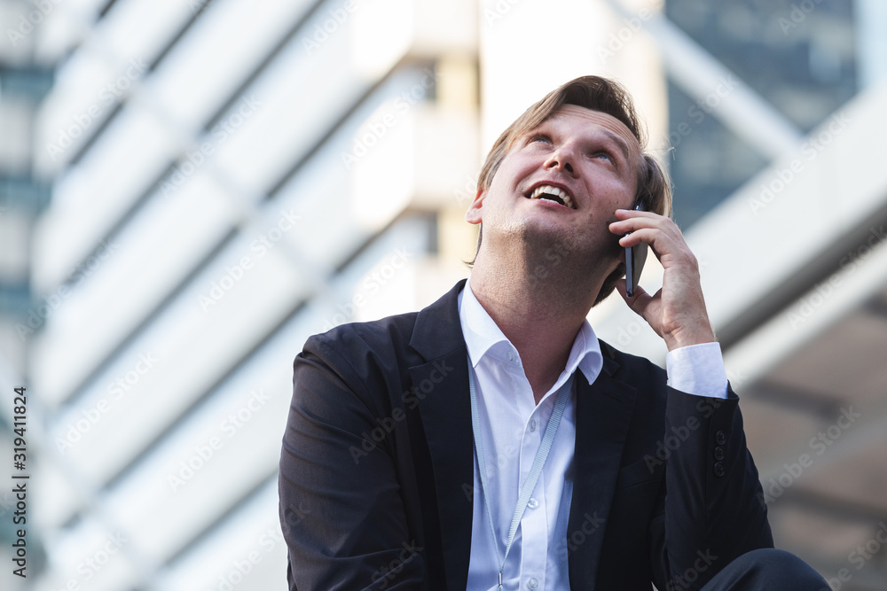 young successful businessman in suit on cell telephone happy, with copy space area. young successful businessman in suit on cell telephone happy, with copy space area.