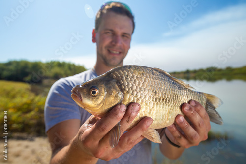 Young happy angler holds the fish