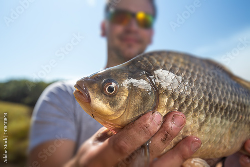 Young happy angler holds the fish