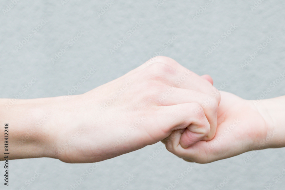 Image of the hands of an adult and a boy