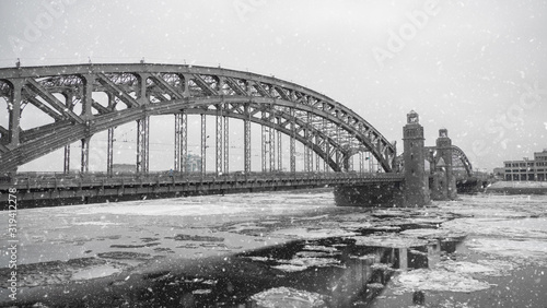 Panorama of a large metal bridge over the river in winter.