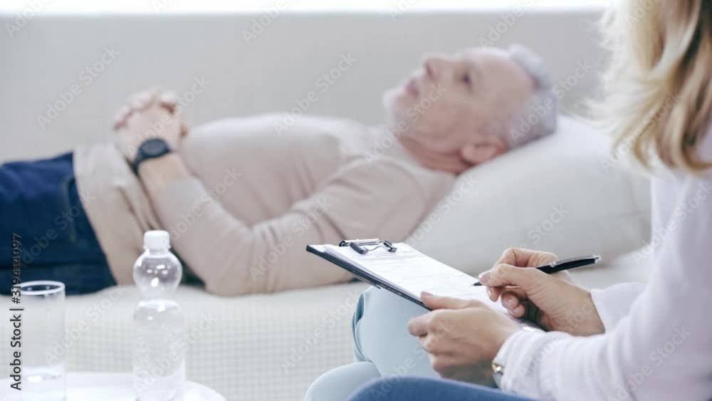 selective focus of mature man lying on couch and talking to psychologist selective focus of mature man lying on couch and talking to psychologist
