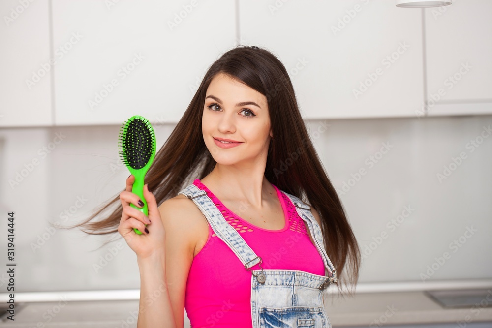 Girl holds a hairbrush without hair and smiling Girl holds a hairbrush without hair and smiling