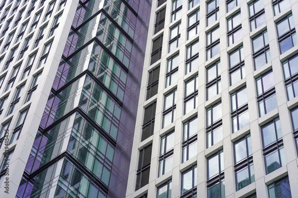Glass blue square Windows of facade modern city business building skyscraper. Modern apartment buildings in new neighborhood. Abstract architecture. Windows of a building, texture. Glass blue square Windows of facade modern city business building skyscraper. Modern apartment buildings in new neighborhood. Abstract architecture. Windows of a building, texture.