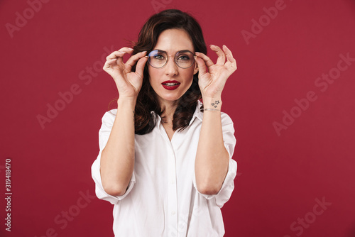 Pretty woman posing isolated over red wall background.