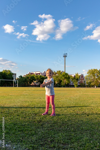 A small child goes in for sports in the stadium. hanging on the horizontal bar, on the uneven bars © Andrey_Chuzhinov