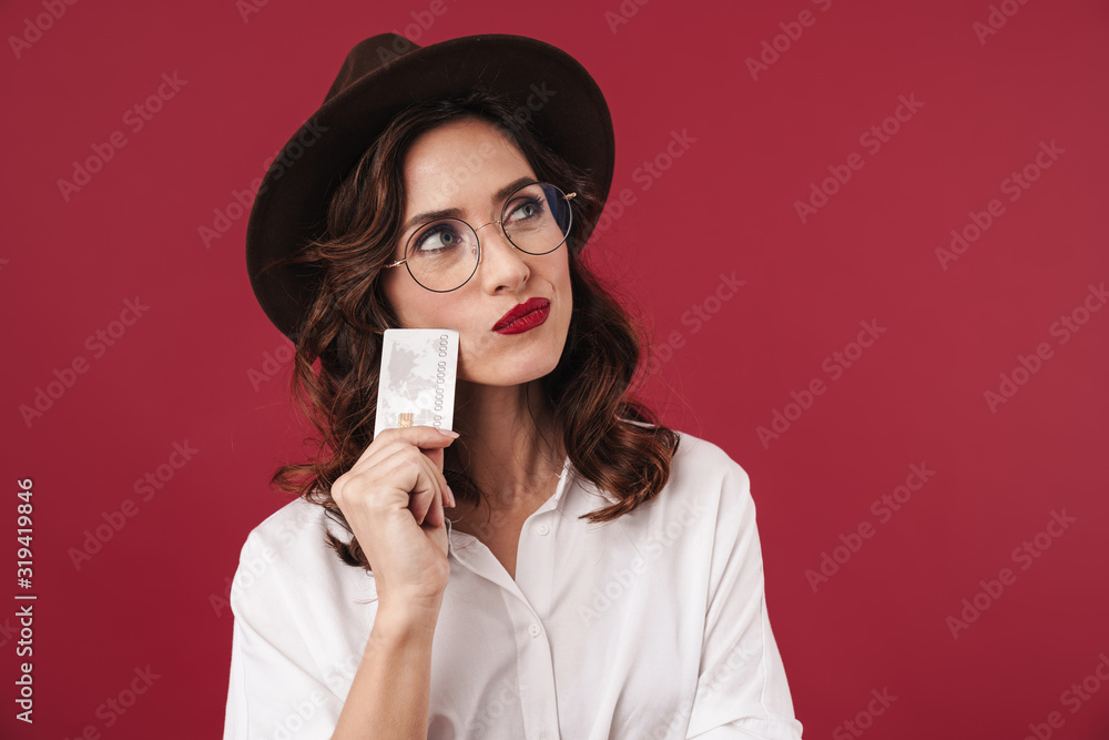 Thoughtful young woman holding credit card. Thoughtful young woman holding credit card.
