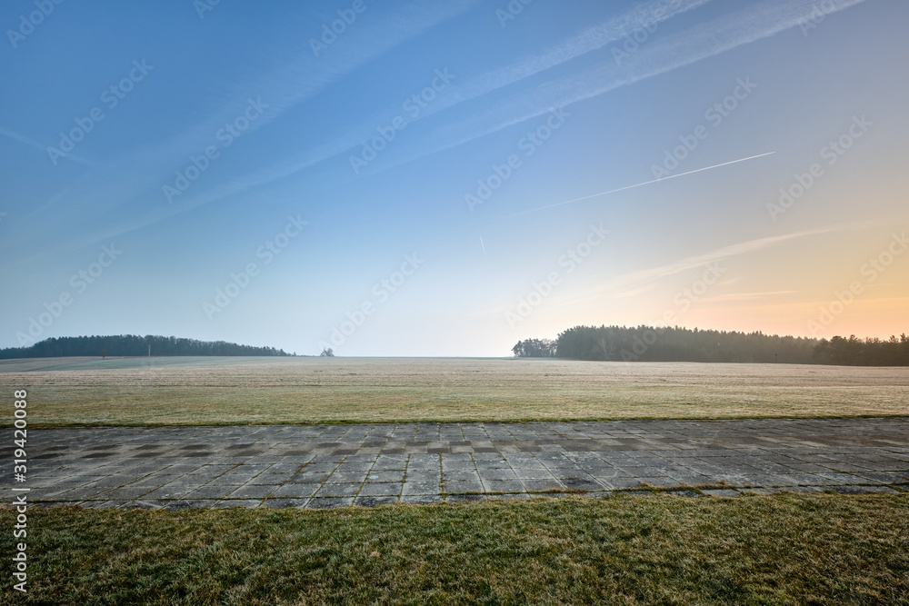 Beautiful countryside landscape with a huge meadow in the foreground in the sunset light in winter. Seen in Franconia / Bavaria near Neunhof in Germany in January Beautiful countryside landscape with a huge meadow in the foreground in the sunset light in winter. Seen in Franconia / Bavaria near Neunhof in Germany in January