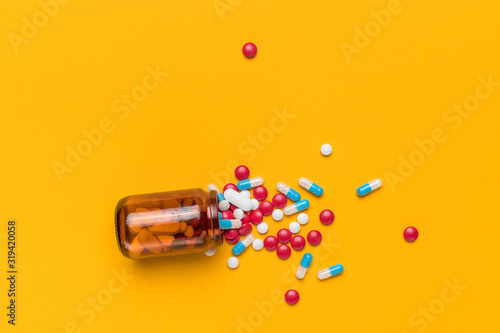 Konstfotografi Film coated pills and capsules spilled from bottle, top view