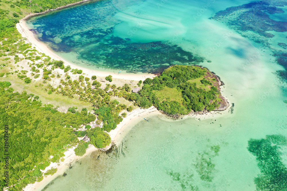A lagoon with a coral reef and a white sandy beach, a view from above.