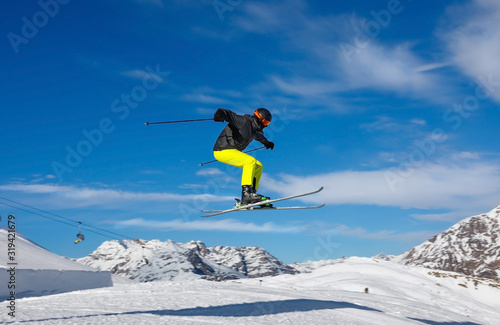 Skier jumps in snow park against the blue sky