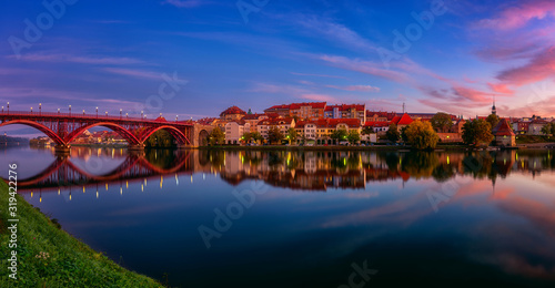 Amazing view of Maribor Old city  Main bridge  Stari most  on the Drava river before sunrise  Slovenia. Scenic cityscape with color sky and reflection  travel background for wallpaper  large panorama