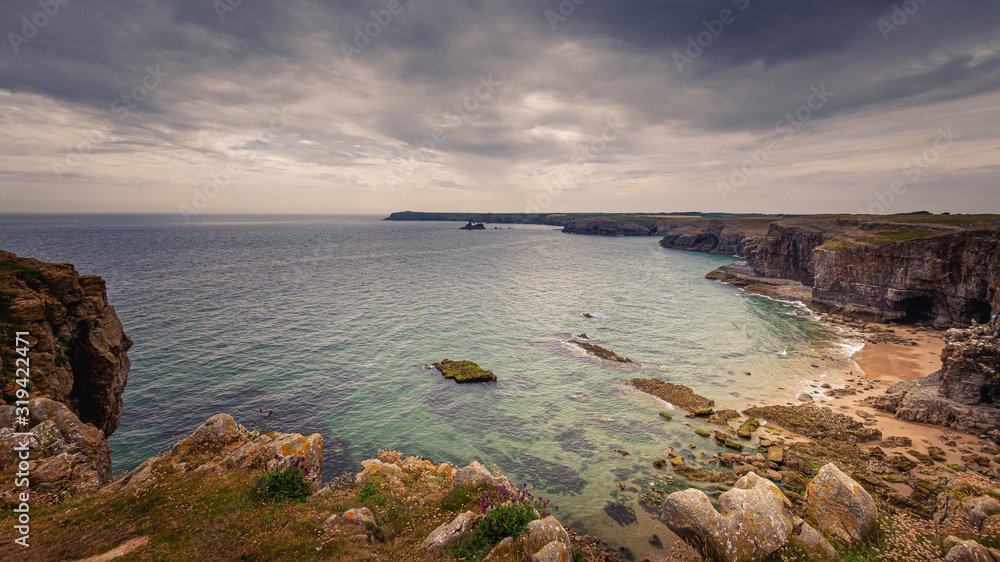 Beautiful bay on scenic coast of Pembrokeshire,South Wales,UK.Moody sky above rocky coastline with cliffs and turquoise water.Tranquil landscape scene.Beautiful seascape.