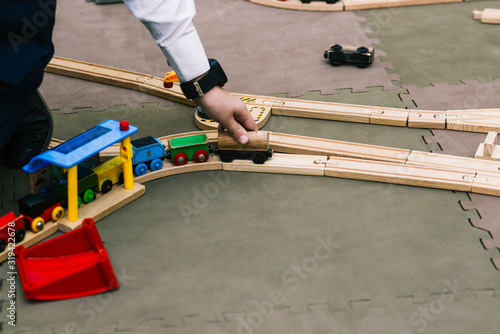 Children's hand drives a toy wooden train. An exciting game for children in kindergarten or school.