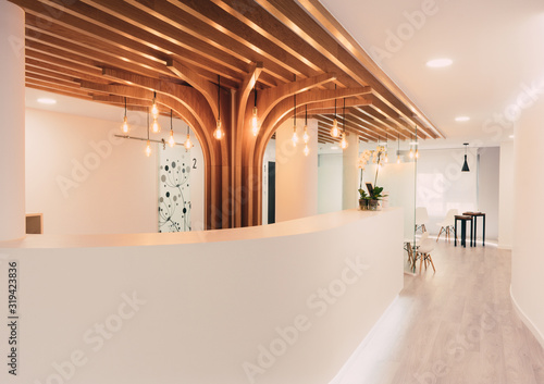 Reception of modern office with lights and wood on the ceiling