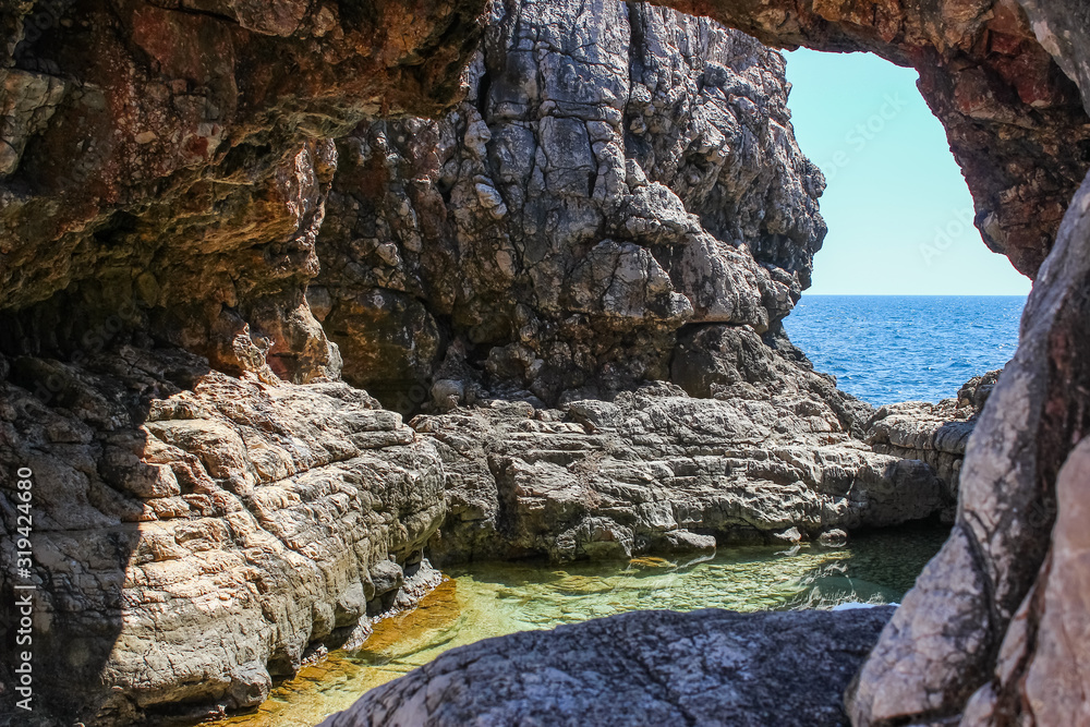 Unique rock arch at Lokrum main beach with beautiful reflection, Dubrovnik, Croatia