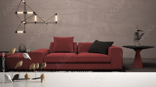 White table top or shelf with minimalistic bird ornament, birdie knick - knack over blurred red colored living room with sofa, lounge, carpet, modern interior design