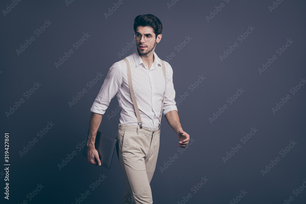 Profile side photo of gorgeous minded guy go work start-up hold computer ready decide solution wear stylish outfit isolated over grey color background Profile side photo of gorgeous minded guy go work start-up hold computer ready decide solution wear stylish outfit isolated over grey color background