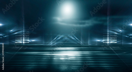 Futuristic empty night scene with spotlights and neon blue light. Reflection on the wet asphalt of the city night lights. Abstraction of light. © MiaStendal