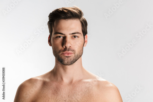 Photo of young half-naked man posing and looking at camera