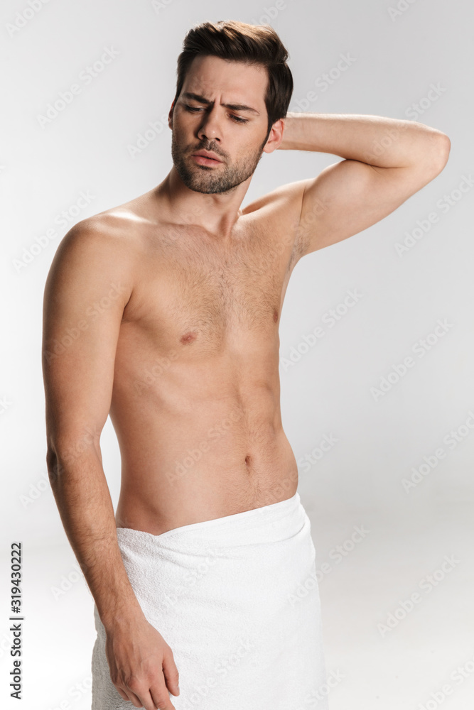 Photo of confused half-naked man posing in bath towel