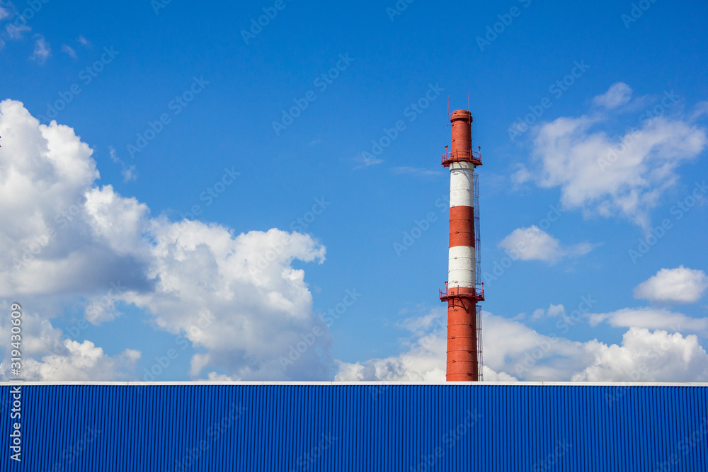 large red white factory chimney against a blue sky large red white factory chimney against a blue sky
