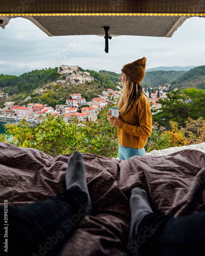 Woman and man in Camper Van enjoying the landscape view during their roadtrip.