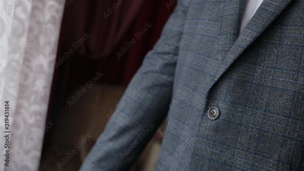 elegant young fashion man looking at his cufflinks while fixing them elegant young fashion man looking at his cufflinks while fixing them