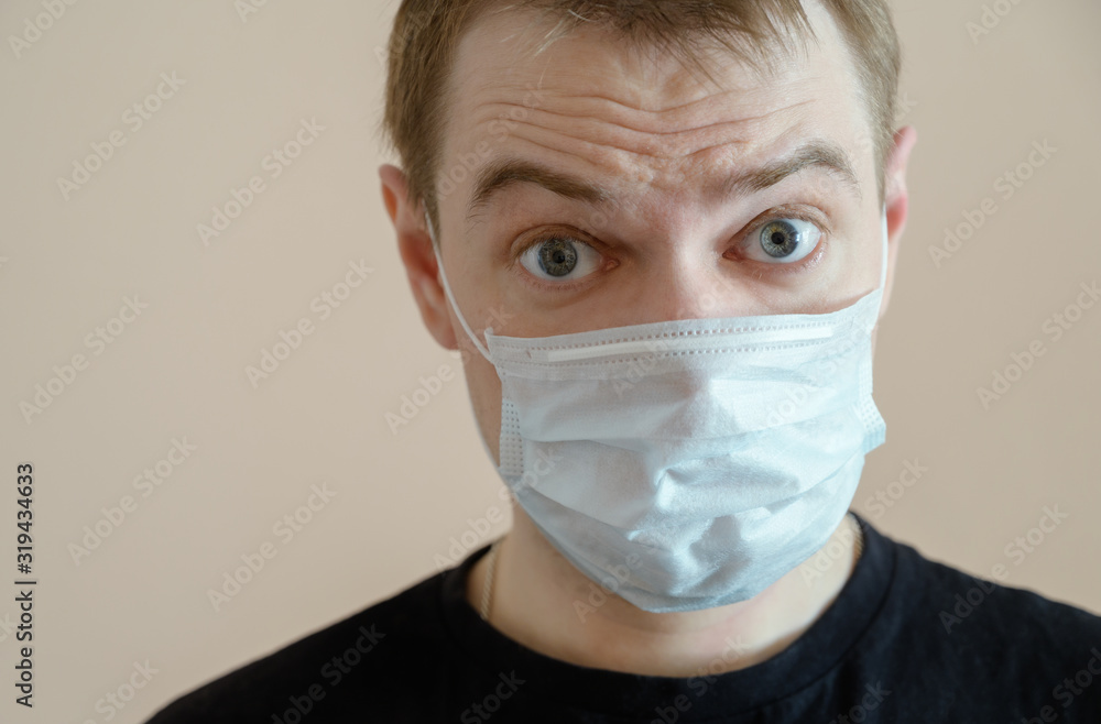 Young man wearing protective medical mask. Selective focus. Young man wearing protective medical mask. Selective focus.