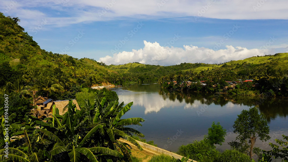River and green hills. Beautiful natural scenery of river in southeast Asia. Countryside on a large tropical island. Small village on the green hills by the river. The nature of the Philippines, Samar
