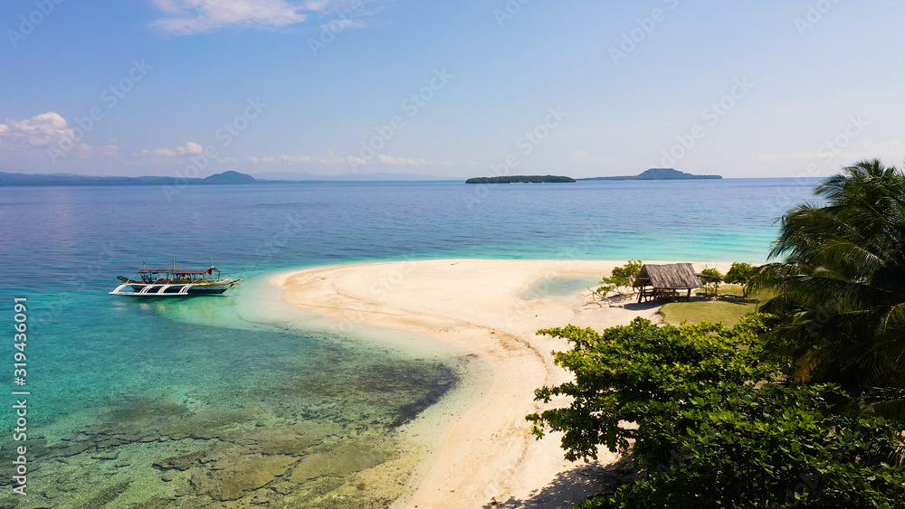 Perfect white sand beach and boat. Tranquil beach scenery. Summer holiday vacation concept. White sand beach. Digyo Island, Philippines.