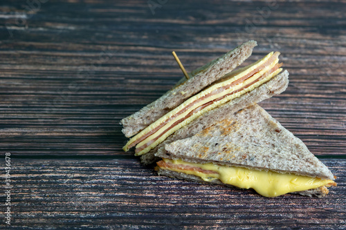 Sandwich ham cheese with Whole wheat Bread made from Riceberry on dark background.