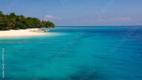 Seascape with a beautiful tropical island, aerial view. Beautiful white sand beach. Mahaba Island, Philippines. Blue sea with turquoise lagoons. Summer and travel vacation concept.