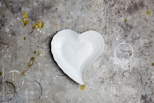 White empty plate in the shape of heart on textured background. Top view, flat lay.