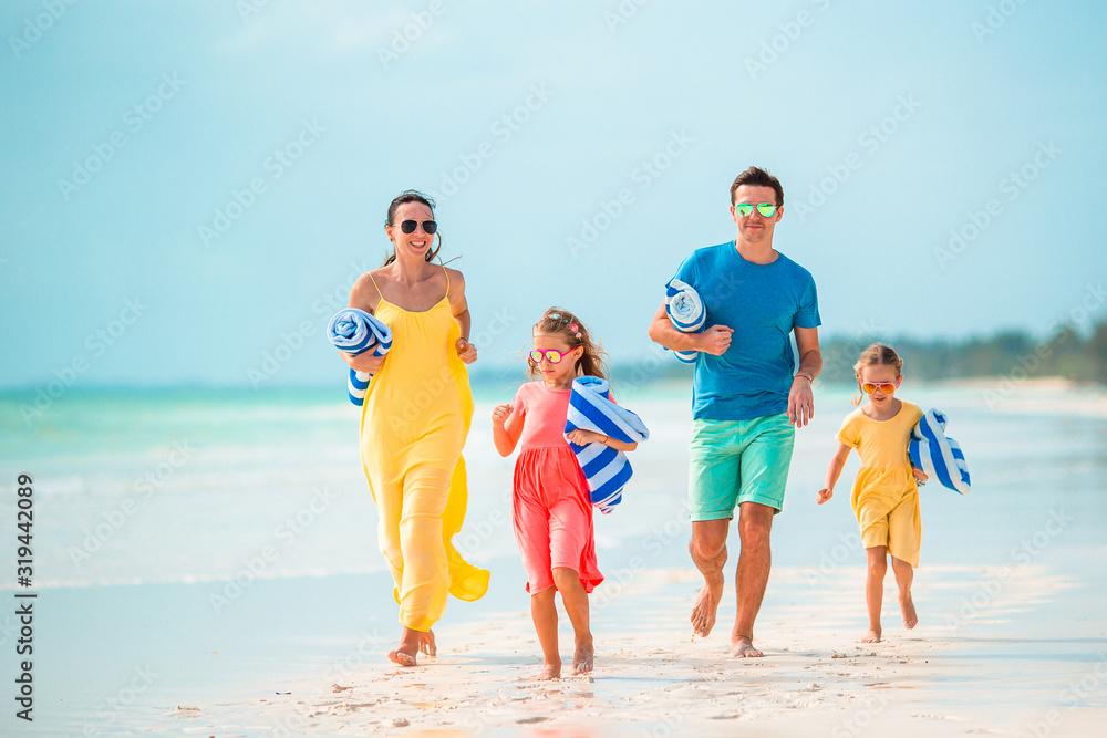 Happy beautiful family of four on the beach