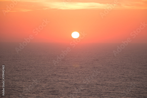 Sunset landscape with the sun in the center over the sea