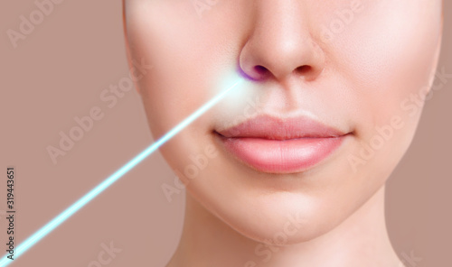 Cosmetics laser ray on beautiful female face. Laser treatment concept. photo