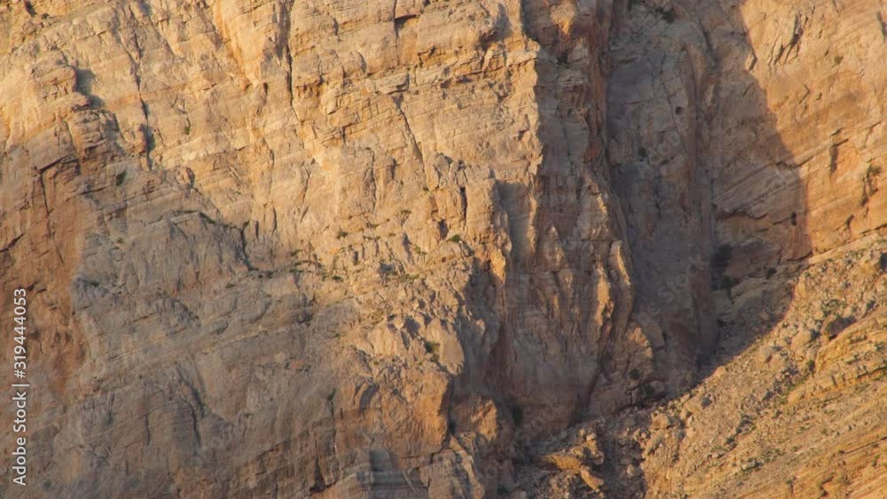 Sunlights on mountain canyon, Stone texture on a mountain face in early morning light, sedimentary mountain limestone rocks texture , Ras Al Khaimah , United Arab emirates Sunlights on mountain canyon, Stone texture on a mountain face in early morning light, sedimentary mountain limestone rocks texture , Ras Al Khaimah , United Arab emirates