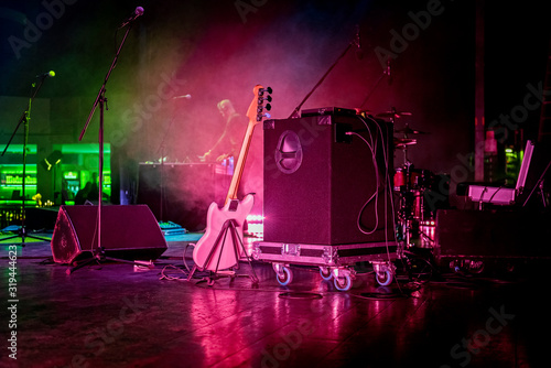Stage with gutar, speakers and smokes in colorful laser lights photo