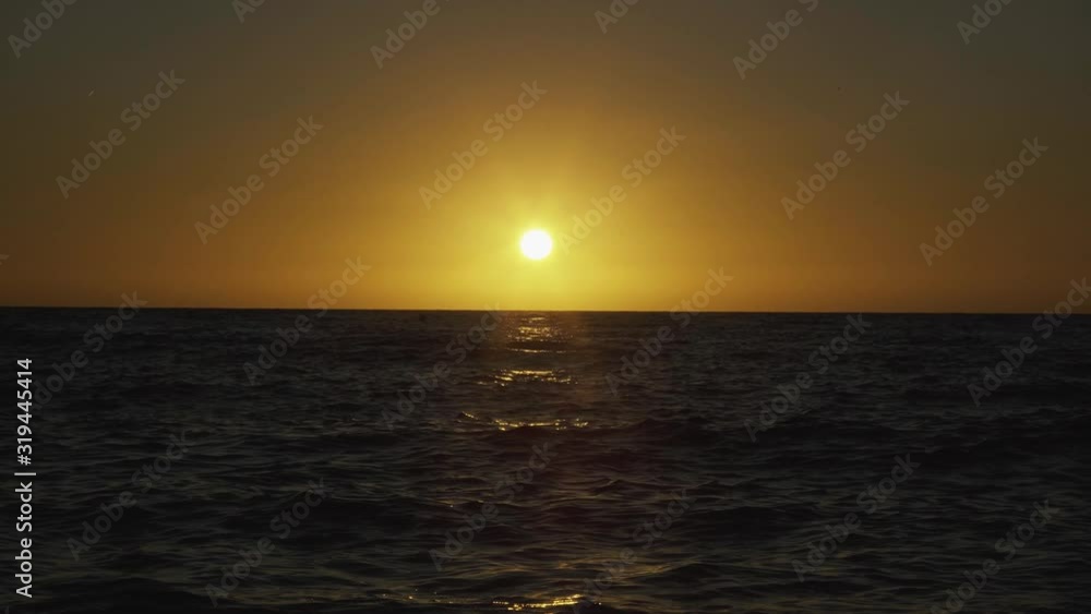 Setting sun paints the sky yellow at the sea