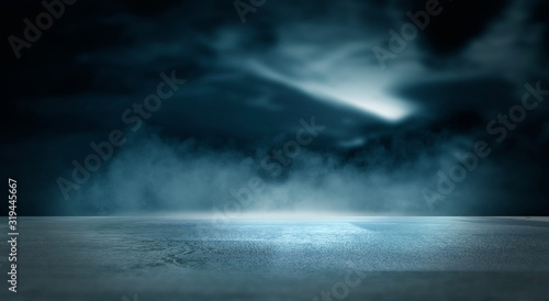 Futuristic empty night scene. Empty street scene background with abstract spotlights light. Night view of street light reflected on water. Rays through the fog. Smoke, fog, wet asphalt with reflection