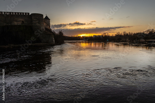 View of a medieval fortress and a river at sunrise