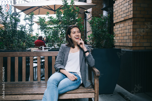 Happy Asian woman sitting on bench