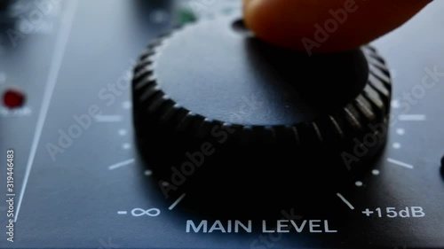 Close up volume knob turning to set levels on audio mixer. Close up 4k