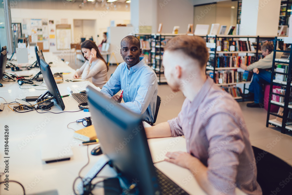 Obraz premium Serious friends communicating in library