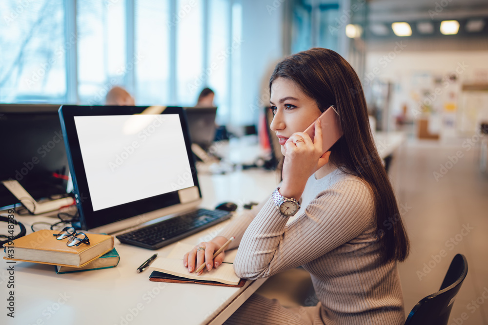 Elegant female speaking on smartphone at workplace Elegant female speaking on smartphone at workplace