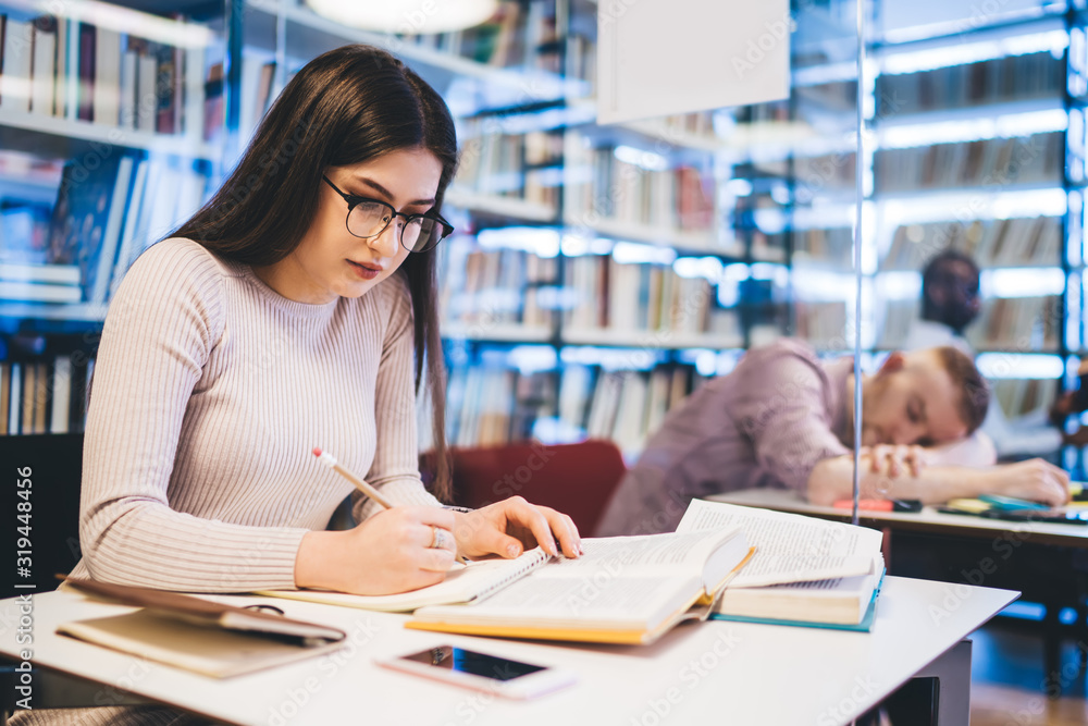 Focused female student studying in library Focused female student studying in library