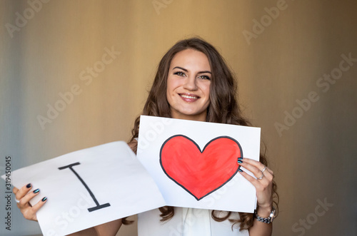 Photography Beautiful smiling brunette woman holding two white cards with i love you words and red heart